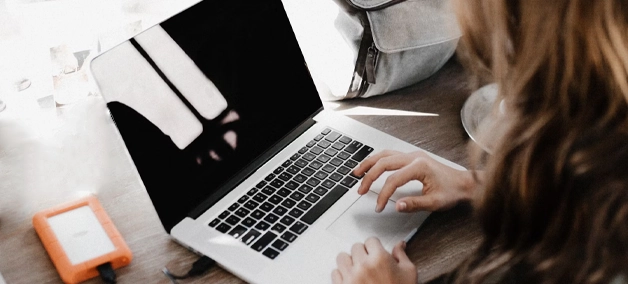 Uso diario de equipos informáticos en entornos empresariales Persona trabajando con un portátil en una oficina, representando el servicio de venta de hardware para empresas